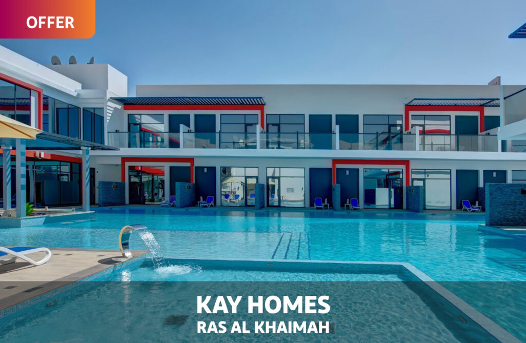 OFFER: Kay Homes, Ras Al Khaimah - pool and water feature outside the white and red two-storey apartment building